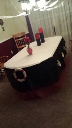 a dining room table covered in black and white cloths with red candles on it