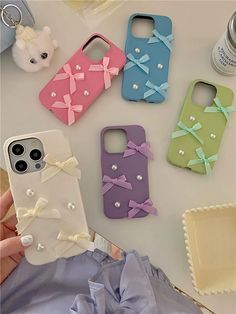 four cell phones with bows and pearls on them