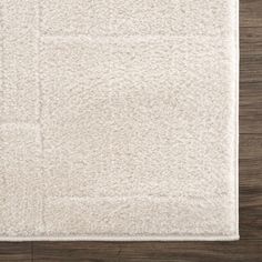 a white rug on top of a wooden floor