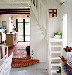 an open kitchen and living room with stairs leading up to the dining area, while another is on the other side of the house