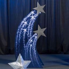 a blue christmas tree with silver stars on it and a white star next to it