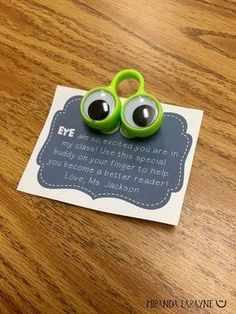 a pair of green eyeballs sitting on top of a piece of paper