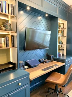 a desk with a monitor, keyboard and mouse on it in front of a bookshelf