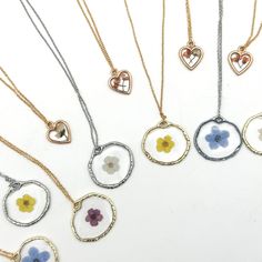 five different necklaces with flowers and hearts on them