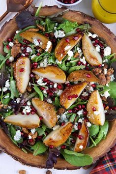 a salad with pears and feta cheese in a wooden bowl on a table