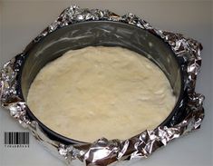 a metal pan filled with dough on top of aluminum foil