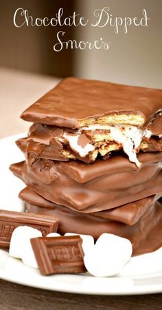 chocolate dipped s'mores on a plate with marshmallows