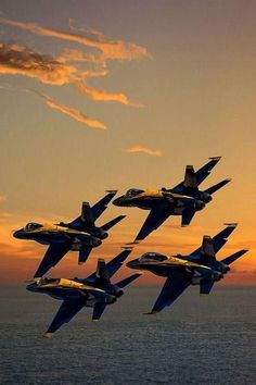 six fighter jets are flying in formation over the ocean at sunset, with clouds above them