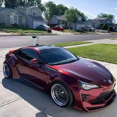 a red sports car parked in front of a house