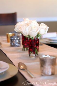 the table is set with white roses and silverware for dinner guests to sit at