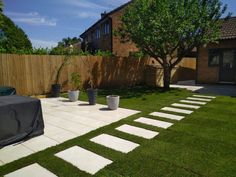 a backyard with grass and stepping stones in the middle