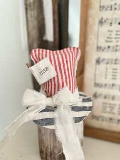 a red and white striped pillow sitting on top of a wooden stand next to a mirror