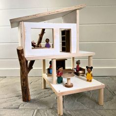 a wooden dollhouse with people in it