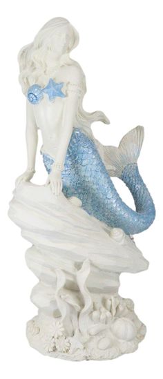 a statue of a mermaid sitting on top of a rock