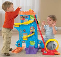 two small children playing with a toy house