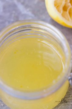 a glass jar filled with yellow liquid next to an orange