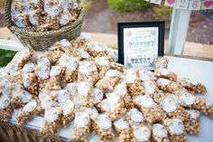 a table topped with lots of desserts next to a basket filled with marshmallows