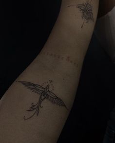 a woman's arm with a bird tattoo on the left side of her arm