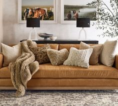 a living room filled with lots of furniture and pillows on top of a brown couch