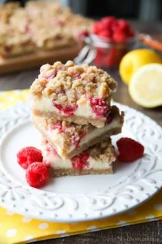 raspberry crumb bars stacked on top of each other with fresh raspberries