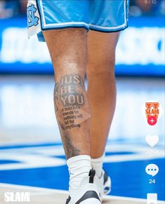 the legs and ankles of a basketball player with tattoos on his leg, while wearing blue shorts