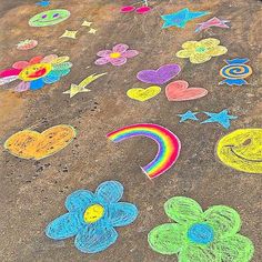 a child's drawing on the ground with flowers, hearts, stars and a rainbow