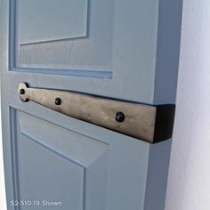 a close up of a door handle on a white door with blue paint and black hardware