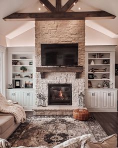 a living room with a couch, fireplace and television on the wall in front of it