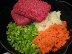 vegetables and meat cooking in a skillet on the stove top, ready to be cooked