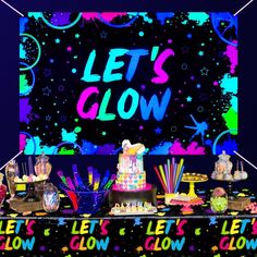 there is a party table with cake and candy on it that says let's glow