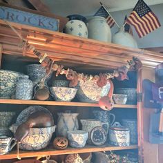 the shelves are filled with pottery and other items