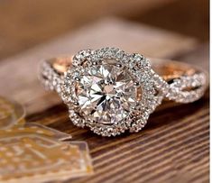 a close up of a diamond ring on a wooden surface