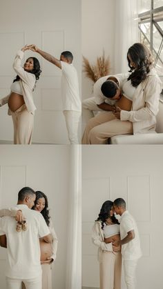 a man and woman hug each other while standing in front of a white wall with windows