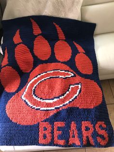 a crocheted blanket with the chicago bears logo on it is sitting on a couch