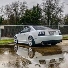 a white sports car parked in a parking lot