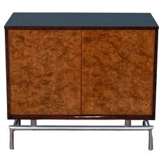 a wooden cabinet with metal legs and black top