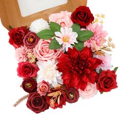 a bouquet of red and pink flowers sitting in front of a wooden box with a mirror