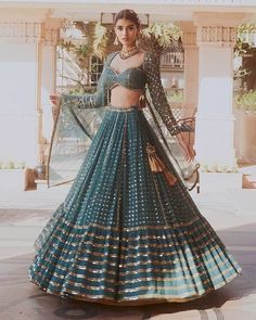 This Lehenga is a beautiful creation in bottle green faux georgette fabric. The lehenga features intricate embroidery with sequins in different sizes--3mm, 5mm, and 9mm--combined with Jari work, giving it a rich and elegant look. With a 4-meter flare and a cancan for added volume, it has a striking presence. The choli (blouse) fabric, also in bottle green, comes with embroidered details, featuring 5mm sequins on the blouse and a mix of 3mm, 5mm, and 9mm sequins on the sleeves, making it stand ou Bottle Green Lehenga Combinations, Bottle Green Lehenga, Umbrella Lehenga, Ghaghra Choli, Mirror Work Lehenga, Saree Bollywood