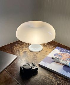 a table with a lamp, book and camera on it