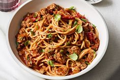 a white bowl filled with spaghetti and meat