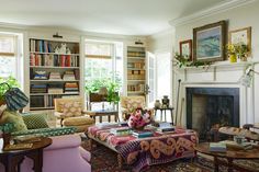 a living room filled with lots of furniture and bookshelves next to a fire place