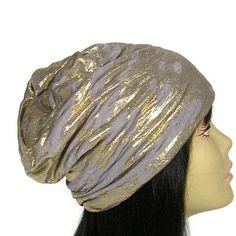 "Work at home and still look good in this glam slouchy beanie High end luxurious metallic gold and taupe lycra blend ...very special... Lined in black cotton jersey Great on short hair...long hair... ...hair up...hair down ...work out...go out ...bad hair day... good My slouchy hats are all designed and made by me in my home studio. Nothing is out-sourced. I am inspired by beautiful and unconventional fabrics. I endeavor to create a truly one-of-a-kind work of art. I love the unexpected...so wil Adjustable Beanie Turban For Winter, Gold Party Hat For Winter, Slouchy Beanie Bonnet, Adjustable Winter Turban, Adjustable Gold Headwrap, Gold Adjustable Headwrap, Gold Headwrap Headband, Gold Headband Turban One Size, Womens Slouchy Beanie