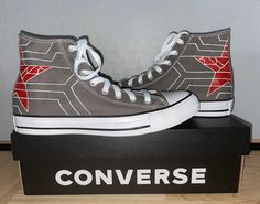 a pair of gray converse sneakers with red and white stars on them