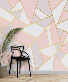 a chair sitting in front of a wall with a pink and gold geometric design on it