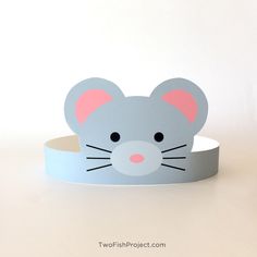 a paper mouse head on top of a white table with a blue ribbon around it