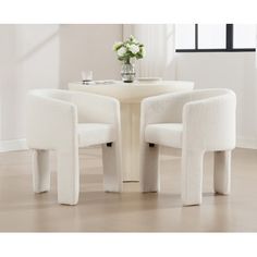 two white chairs and a table in a room