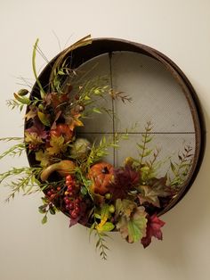 an arrangement of flowers is placed on the wall in front of a round window sill