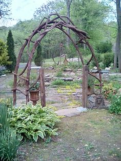 a wooden arch in the middle of a garden