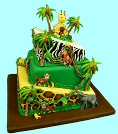 a green and yellow cake with giraffes, monkeys, and zebras on it