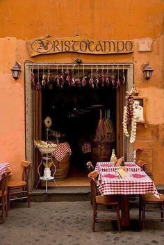 an outdoor restaurant with red and white checkered table cloths on the tables outside